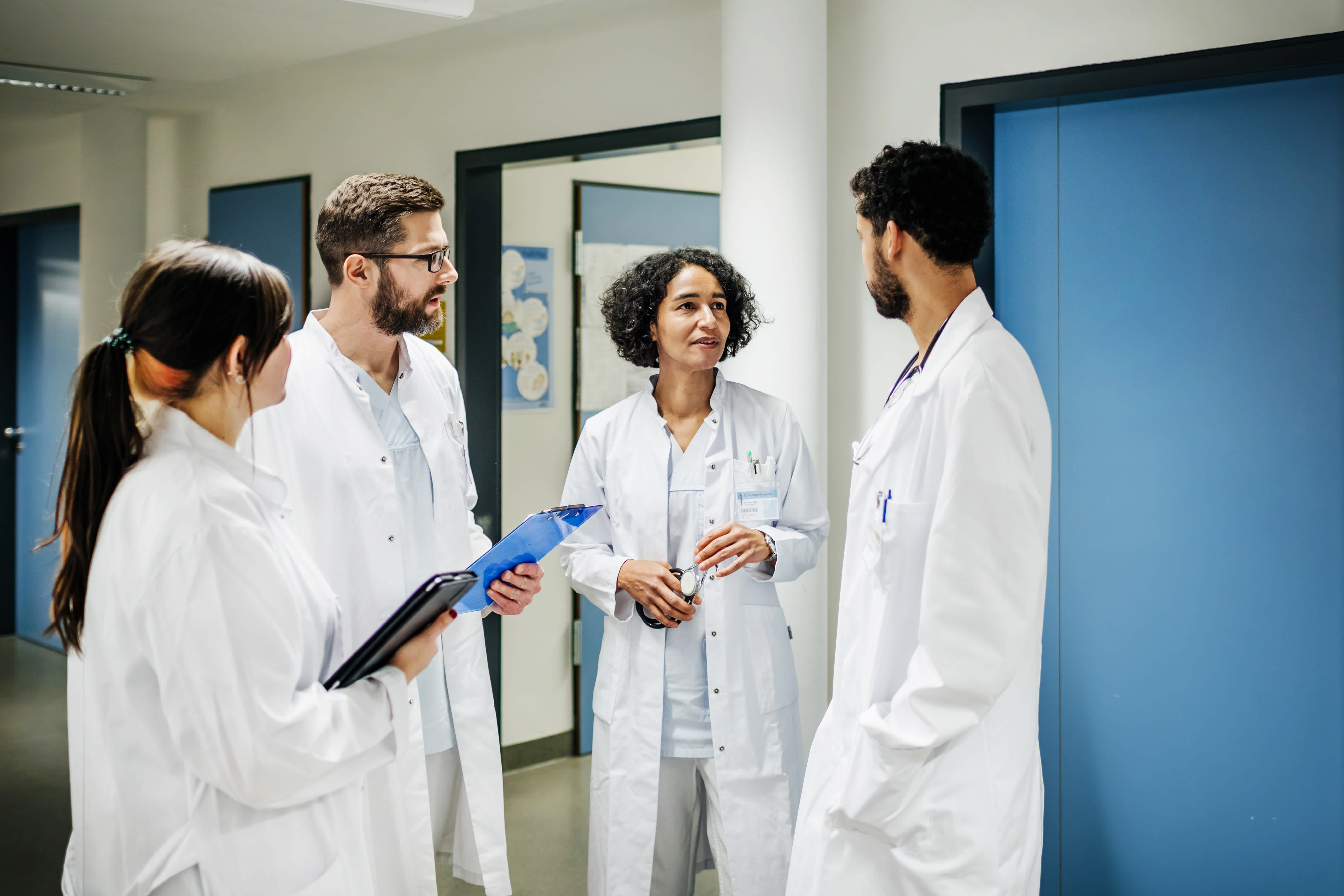 Four physicians speaking with eachother in hospital